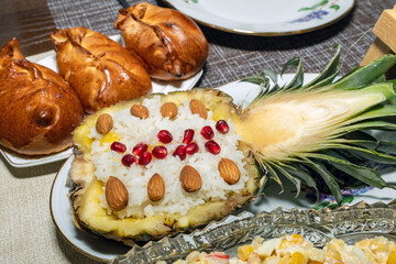 Rice with almonds, sweets, pomegranate in pineapple.