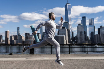 Man sportsman running for exercise in active wear. Sportsman jogger running. Sport runner in Manhattan. The sportsman running at view to New York. Break a record