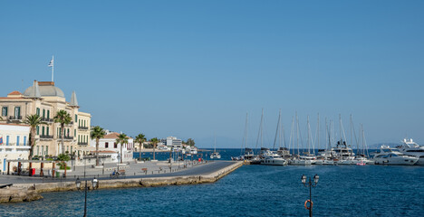 Naklejka premium Spetses island, Greece. Old neoclassical buildings, Yachts and sailing boats anchored at marina, blue sky