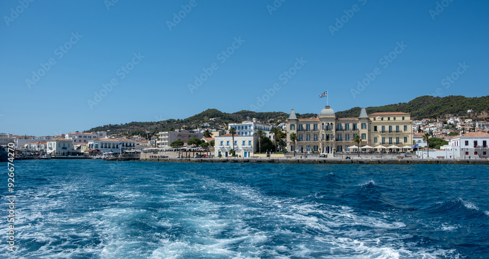 Wall mural Spetses island, Greece. Seafront buildings and motor boats taxis at small port of Dapia