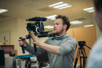 Director of photography with a camera in his hands on the set. Professional videographer at work on...