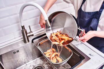 A woman is washing shrimp in a sink