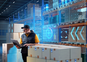 Businessman on treasure. Man supervisor of modern storage. Guy with laptop near warehouse racks....