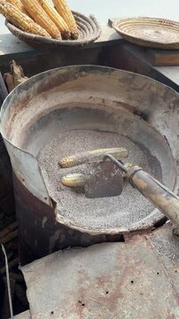 Corn cob roasted in salt. Bhutto roasted in salt. Corn cob street food. Challi in street food. 