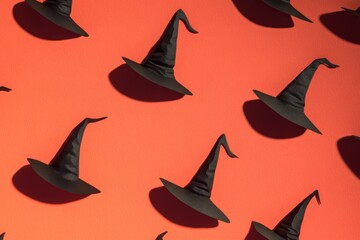 Pattern Black witch hats arranged in a pattern on a red background. Perfect for Halloween party decorations.