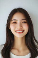 Naklejka premium A woman with long brown hair smiling at the camera
