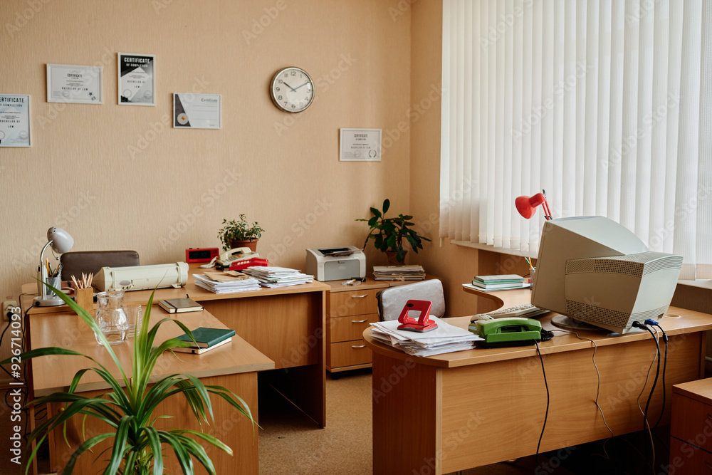 Poster well-organized office space with desks, computers, plants, and documents creating an efficient and w