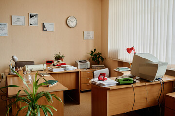 Fototapeta premium Well-organized office space with desks, computers, plants, and documents Creating an efficient and welcoming workplace environment