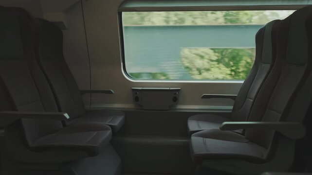 View from inside the train of empty seats and the landscape outside the window