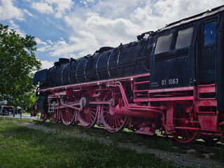 Naklejka premium old steam locomotive, which is black and red and stands at the main station in Braunschweig as a museum piece