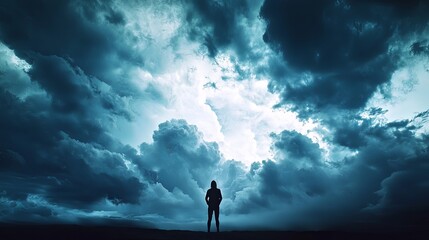 A dramatic stormy sky combined with the silhouette of a person standing strong, with large open areas for text or additional graphics. High resolution 8K