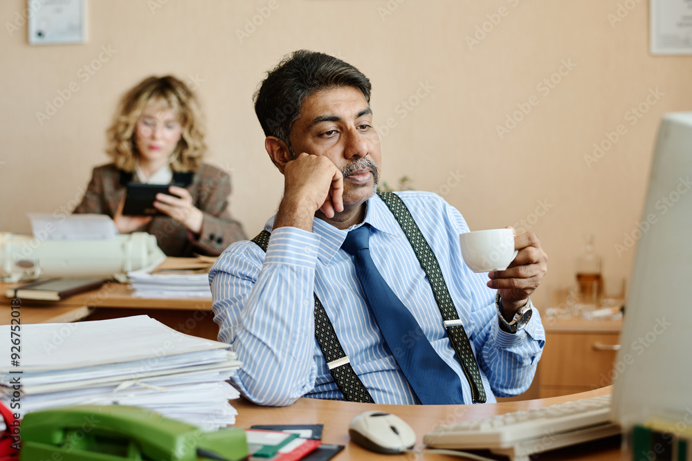 Aufkleber man holding coffee cup, wearing shirt and tie, sitting at desk with paperwork while thinking deeply.