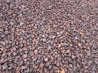 Slag Pumice natural stone decoration full frame background. volcano stone, red volcanic pumice with glass, cold piece of lava, basalt extrusive igneous rock, porous red volcano stones top view.