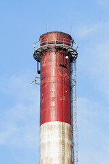 An industrial chimney against a clear sky, painted white and red | Komin przemysłowy na tle czystego nieba, pomalowany na biało-czerwono