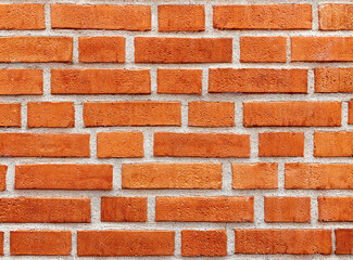 Texture of a red brick wall with straight lines of cement joints. Protruding bricks. Text space....