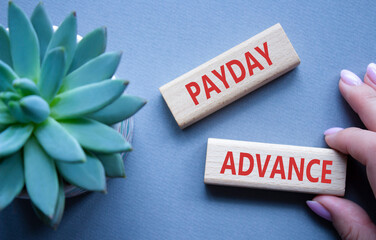 Payday Advance symbol. Concept word Payday Advance on wooden blocks. Beautiful grey background with...