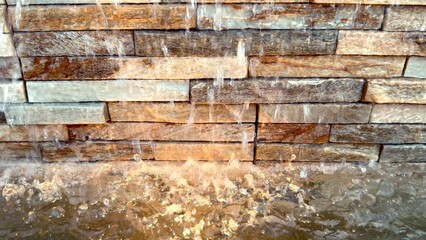 Crystal-clear water cascades from decorative fountain, gracefully arcing through air Gentle droplets create soothing and rhythmic sound as they splash against stone wall adding calming ambiance 