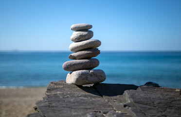 Zen style stone stack on the beach on a bright summer day indicating balance and community