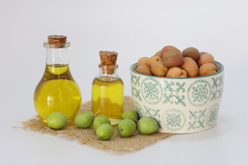 olive oil and pickled green olives on white background