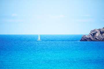 Obraz premium White sailing yacht in blue waters of the Mediterranean Sea in Spain