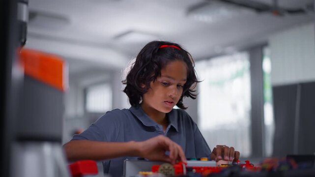 Portrait of schoolboy building robot in after-school robotics club. Children learning robotics in Elementary school. Science for kids.