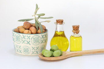 olive oil and pickled green olives on white background