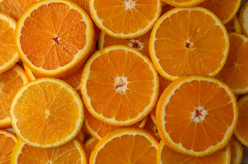 Slices of pulp and zest ripe orange with backlighting as a textural background