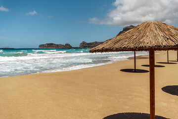 Empty sandy beach with umbrellas in summer with sun light.