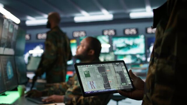 Army professional employing AI tech to improve military combat systems and missiles monitoring. African american IT admin uses neural networks to enhance combat operational capabilities, camera B