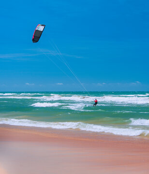 Practice of Kiteboarding or kitesurfing, a sport that involves using wind power with a large power kite to pull a rider across a water, land, snow, sand. Cumbuco Beach, Fortaleza, Ceara, Brazil. 2020