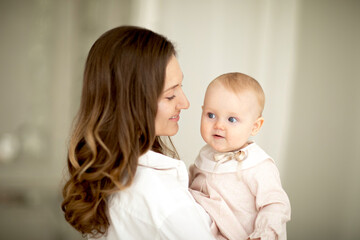 Close-up head shot side view of a mother and her infant daughter. Blurred portraits. Moment of tenderness and affection between mother and baby.