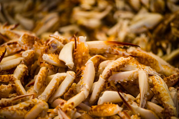 an abundance of stacked fresh crab legs, varying in color from white to brown