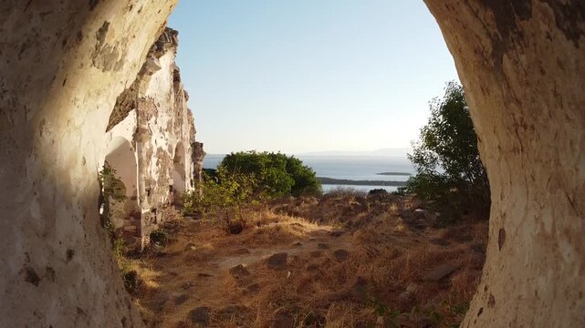 A drone flight through the window of a ruin. A church once stood on a hill on the Turkish coast of Cesme Izmir.