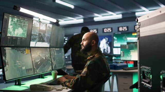 Special forces professional in military HQ base gathering information on enemy troops. Officer using monitoring equipment in base of operations to do assessment of enemy vulnerabilities, camera B