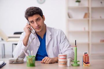 Young male dentist working in the clinic