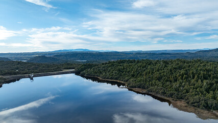 Remote Kapitea Reservoir reflections surrounded by mountain ranges , near Kumara West Coast NZ