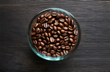 Coffee beans in glass on a dark wooden background