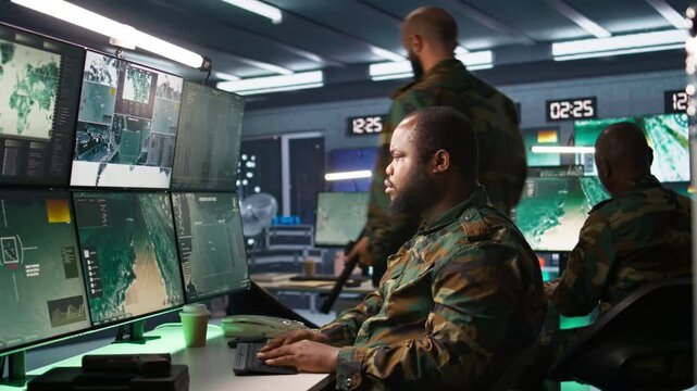 Military officer making telephone call to relay enemy info gained using tracking equipment. Army specialist talking on phone, giving intel helping troops, coordinating mission activities, camera B