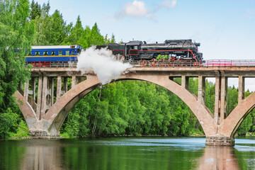 Retro train moves above the river.
