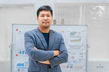 Fototapeta premium Asian business team, dressed in formal suits, works at a desk analyzing financial charts. strategies for managing inventory and optimizing distribution channels in retail and wholesale businesses.