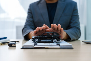 Asian business professional in a formal suit works at a desk, reviewing financial charts. manage car insurance claims, analyze auto loan options, sign lease agreements for vehicle transactions.