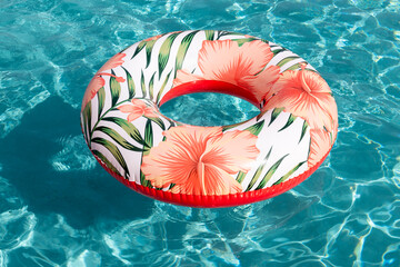 Swimming ring floating on a swimming pool. Colorful swim tube floating on a blue swimming pool.