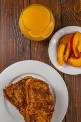 French toast on a plate with blueberries, orange juice, nectarine for breakfast