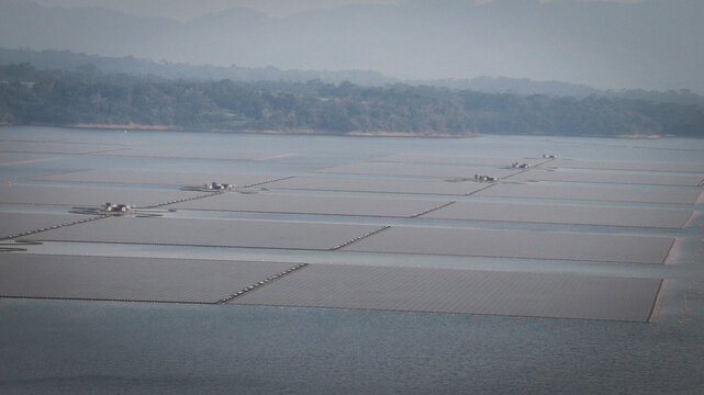 Aerial view of vast floating solar panels on Cirata Reservoir in West Java, Indonesia, showcasing innovative renewable energy technology amidst serene natural surroundings