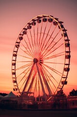 Large Ferris Wheel at Sunset with Pink and Orange Skies