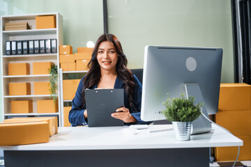 A young Asian businesswoman sits at her table, watching the computer screen.She analyzes, plans,...