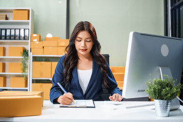 A young Asian businesswoman sits at her table, watching the computer screen.She analyzes, plans,...