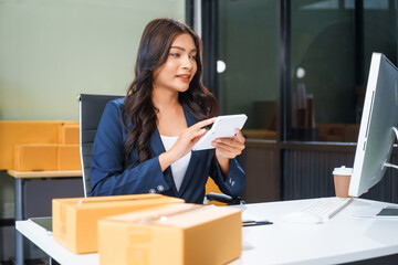 A young Asian businesswoman sits at her table, watching the computer screen.She analyzes, plans,...