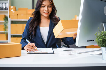 A young Asian businesswoman sits at her table, watching the computer screen.She analyzes, plans,...