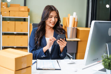A young Asian businesswoman sits at her table, watching the computer screen.She analyzes, plans,...